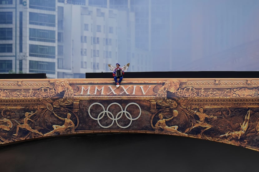 Una artista se sienta en un puente en París, Francia, durante la ceremonia de apertura de...