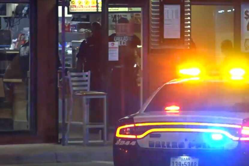 Dallas police officers investigate a shooting that left one employee wounded Wednesday...