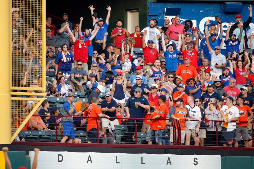 Texas Rangers fans cheers as batter Shin-Soo Choo's home run ball clears the left field wall...