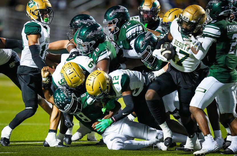 As DeSoto  linebacker Jamari Laye (9) and defensive back Canden Mathis (12) bring down...