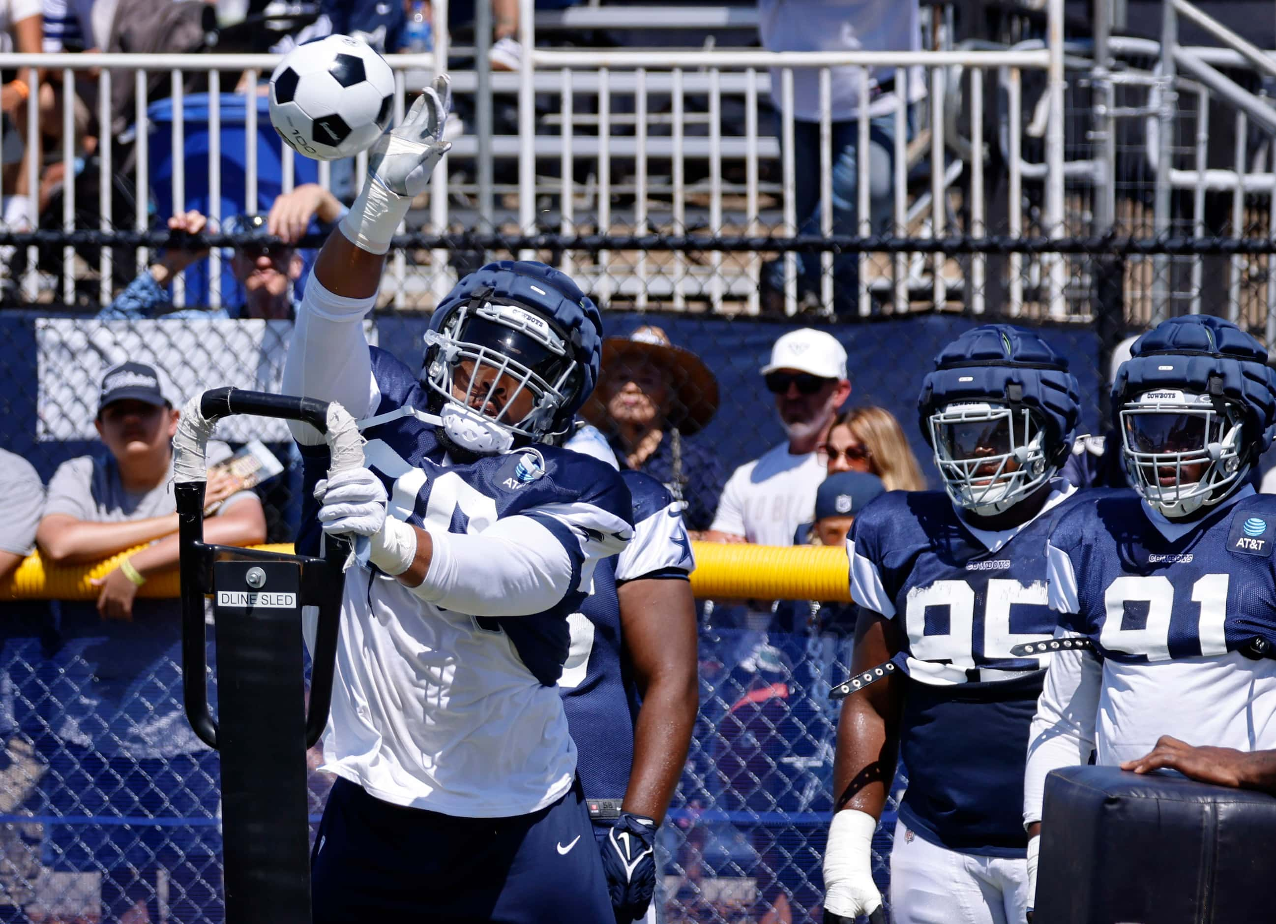 Dallas Cowboys defensive tackle Carl Davis (98) reaches to bat a thrown soccer ball during a...