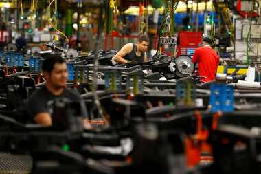  An employee attaches brake components on a chassis at the GM Plant in Arlington, Texas May...