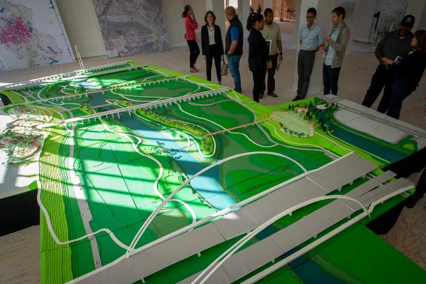 Visitors look at a model of Harold Simmons Park on exhibit at at Old Dallas High School in...