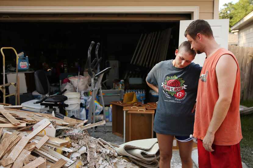 Sarah Dill and her husband, Josh Dill, consoled each other outside their home in Kingwood on...