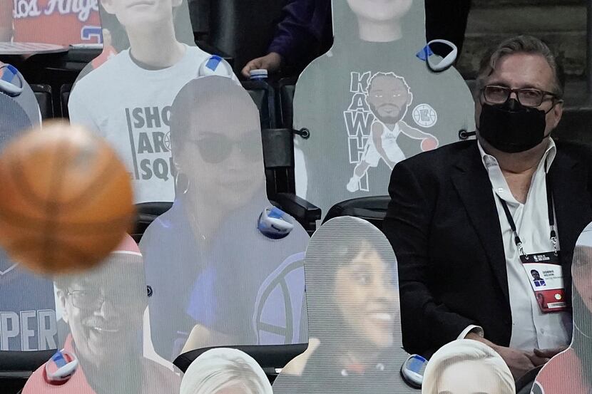 Dallas Mavericks general manager Don Nelson watches from a sea of cutouts during the first...