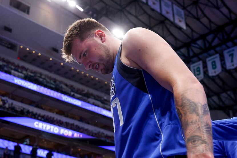 Dallas Mavericks guard Luka Doncic (77) limps off the court after injuring his lower left...