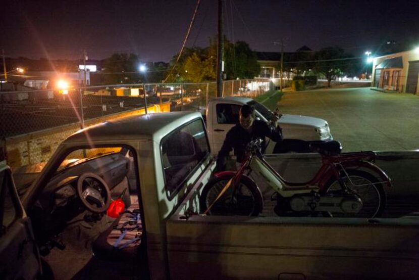 
Roger Thompson, of Flower Mound, Texas, straps his moped down in the back of his pickup...