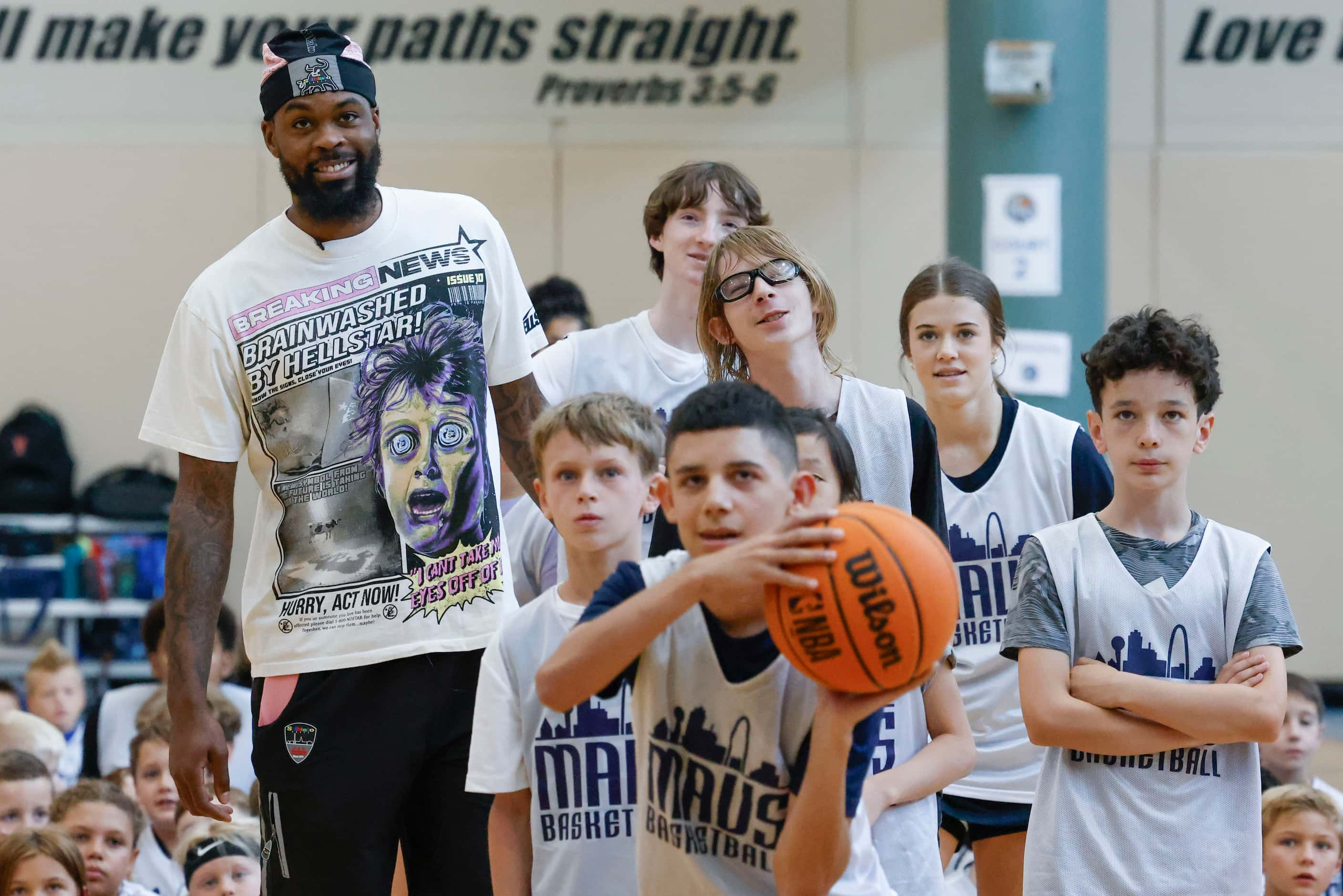 Dallas Mavericks’ Naji Marshall, watches as young basketball campers play ball during a Hoop...