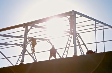 Workers erect a temporary tent in preparation for the AT&T Byron Nelson Golf Tournament at...