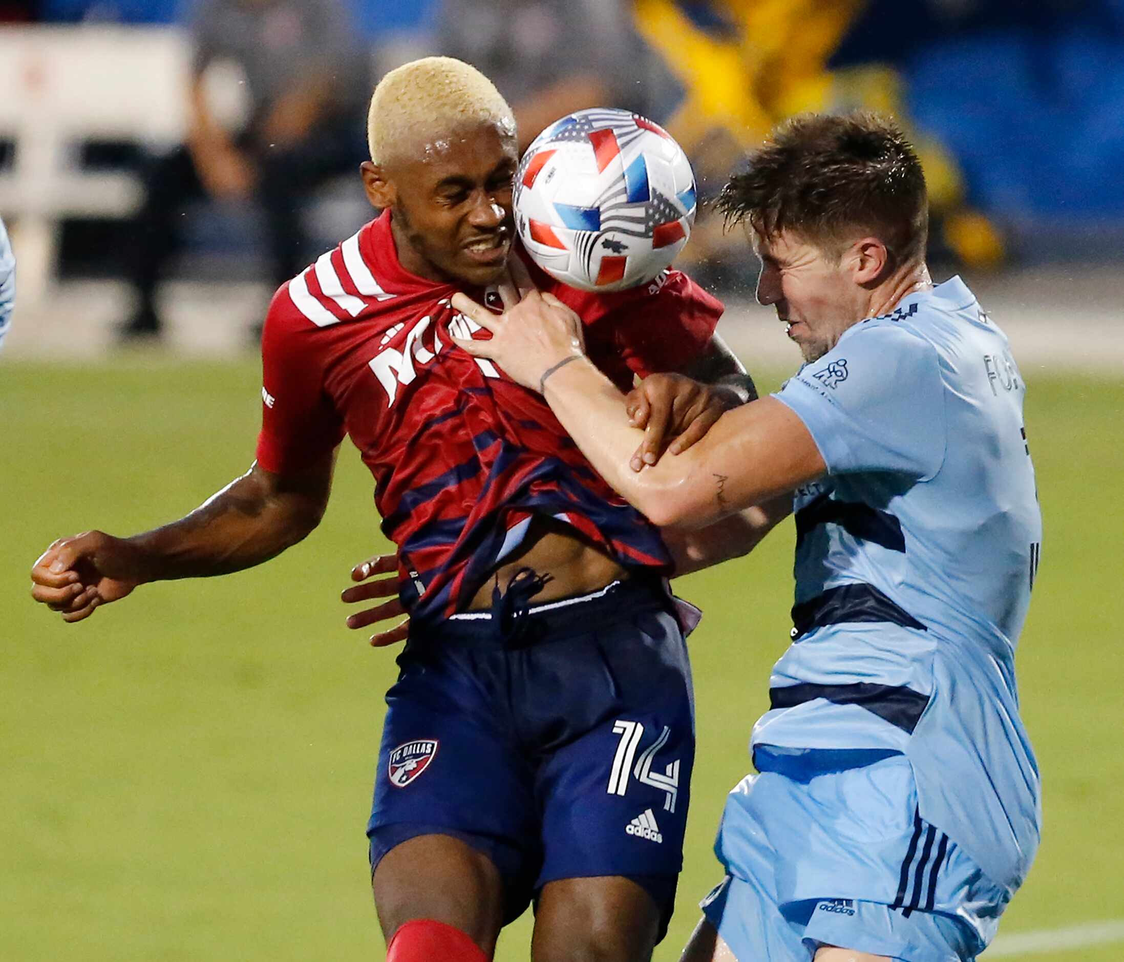 FC Dallas defender Nkosi Burgess (14) battles for the soccer ball with Sporting Kansas City...