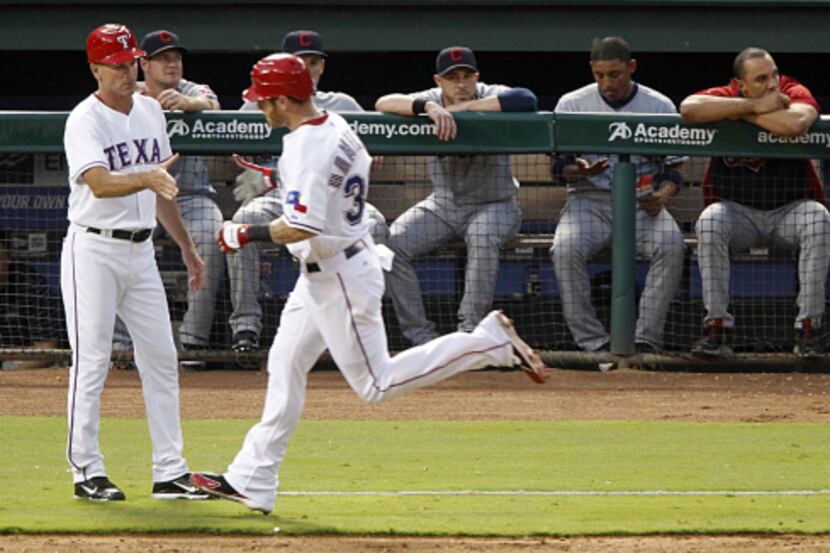 The Cleveland Indians bench can only watch as Texas Rangers Josh Hamilton rounds third base...