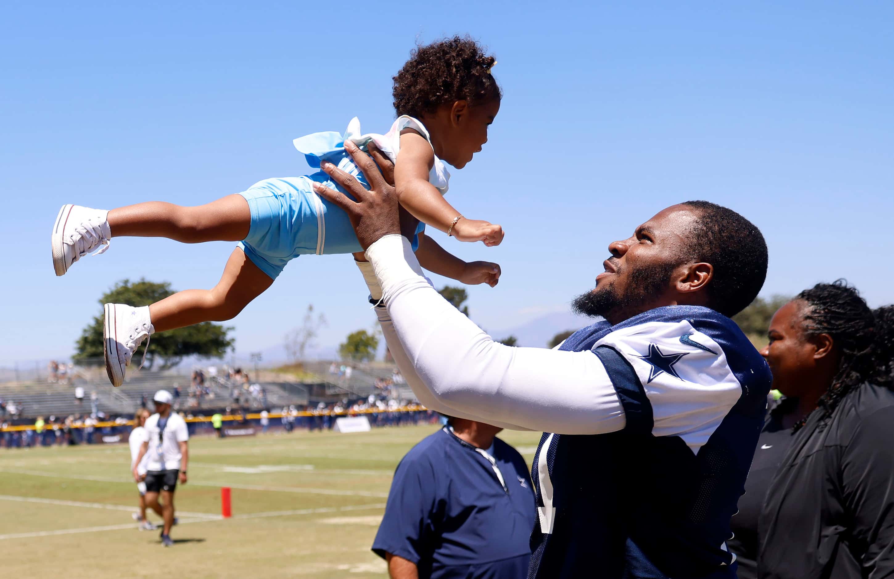 Dallas Cowboys linebacker Micah Parsons tosses his daughter Milana following a training camp...