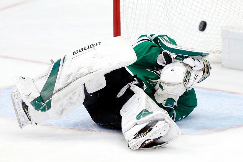 The puck bounces back into play after Dallas Stars goaltender Ben Bishop (30) took a...