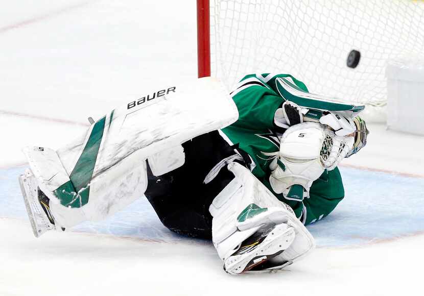 The puck bounces back into play after Dallas Stars goaltender Ben Bishop (30) took a...