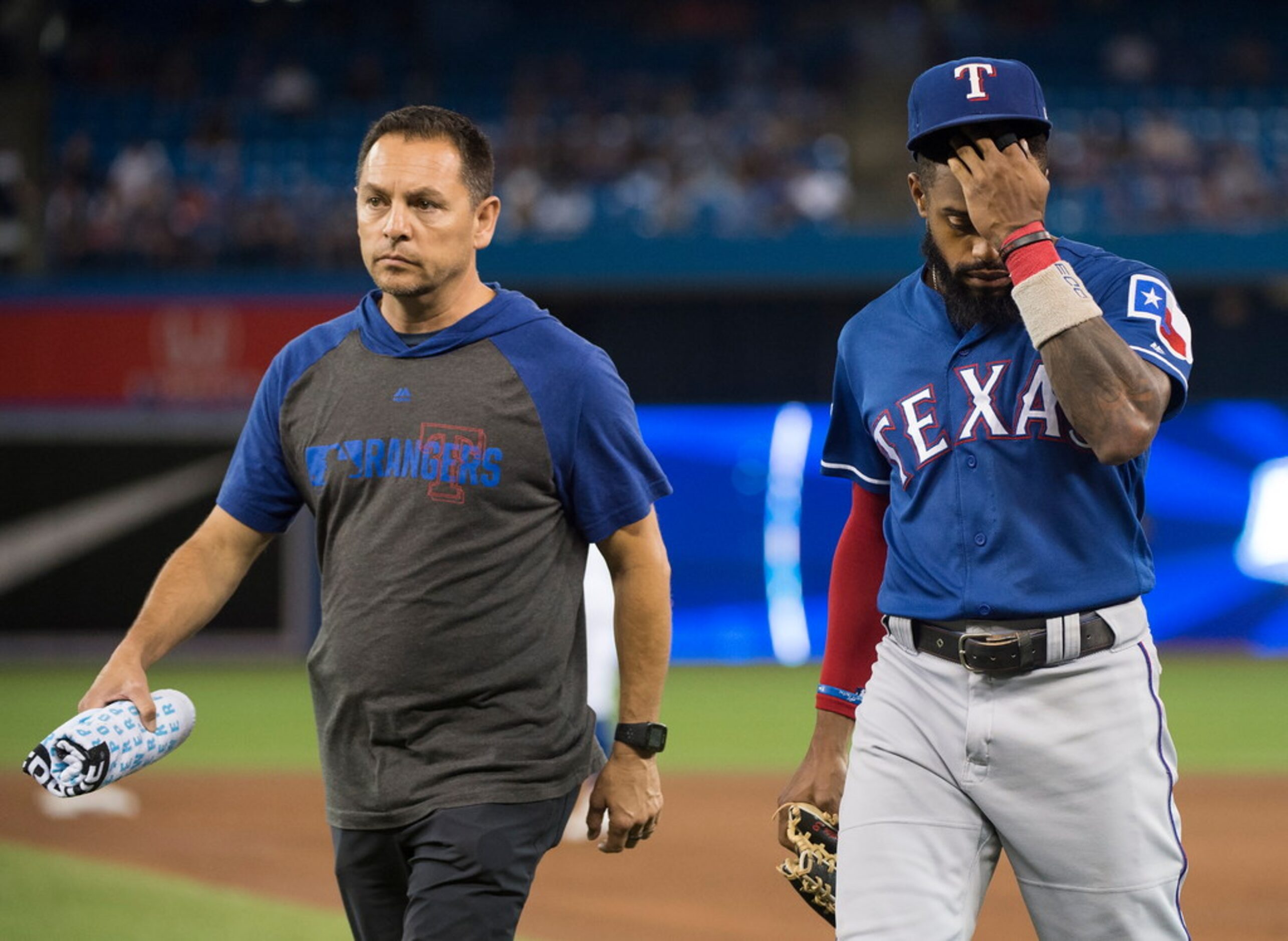 Texas Rangers center fielder Delino DeShields, right, walks back to the dugout with the...