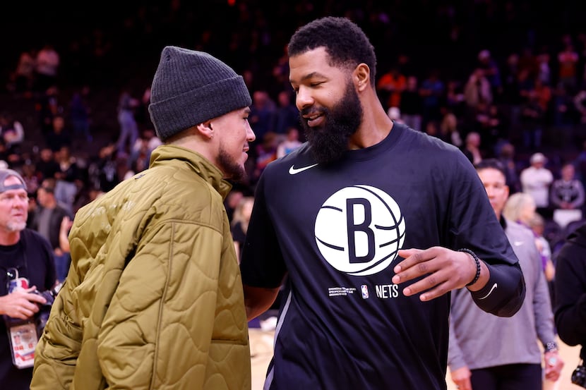 Devin Booker of the Phoenix Suns hugs Markieff Morris of the Brooklyn Nets after the Suns...