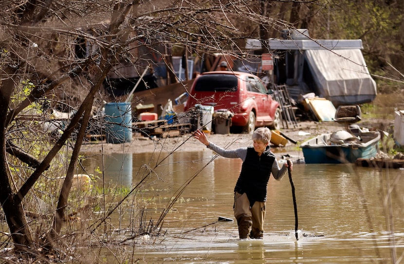 Dallas Morning News columnist Sharon Grigsby navigates the receding floodwater along the...