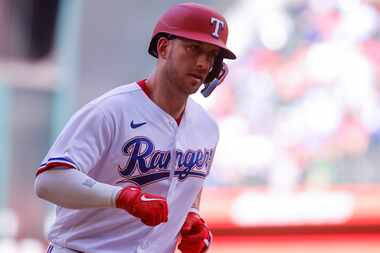 Texas Rangers catcher Mitch Garver runs between bases after hitting a home run during the...