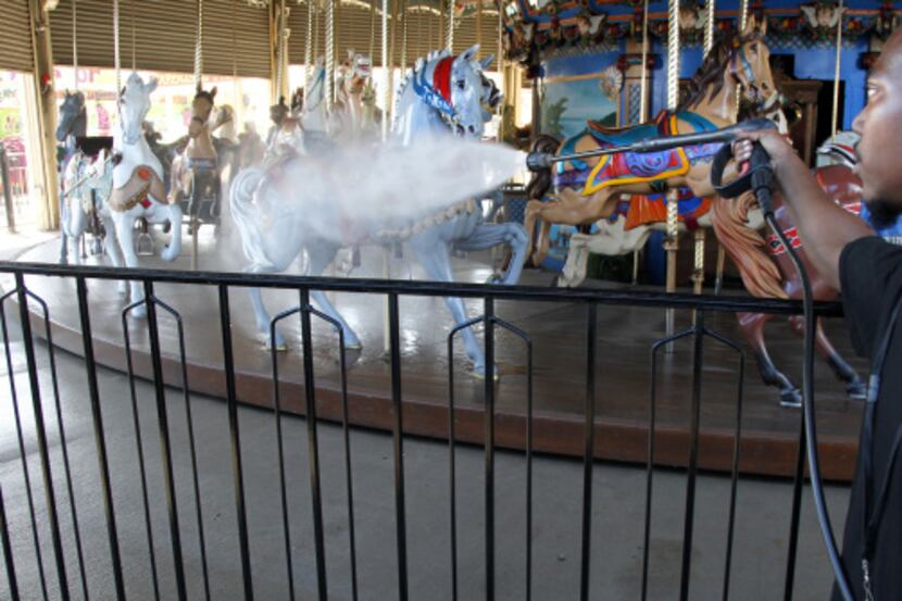 Getting ready to ride: Ellis Holton washed the carousel horses on the midway at Fair Park...