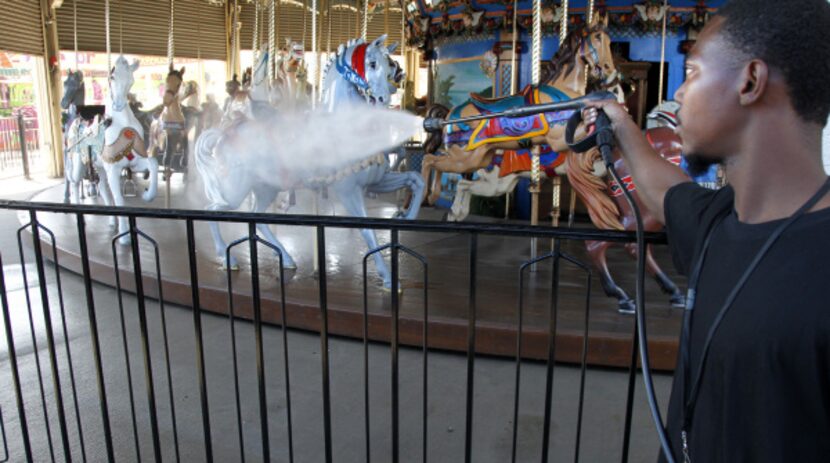 Getting ready to ride: Ellis Holton washed the carousel horses on the midway at Fair Park...