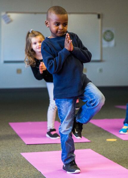 Joshua Oatis and other kindergarteners work on balance and other yoga principles during a...