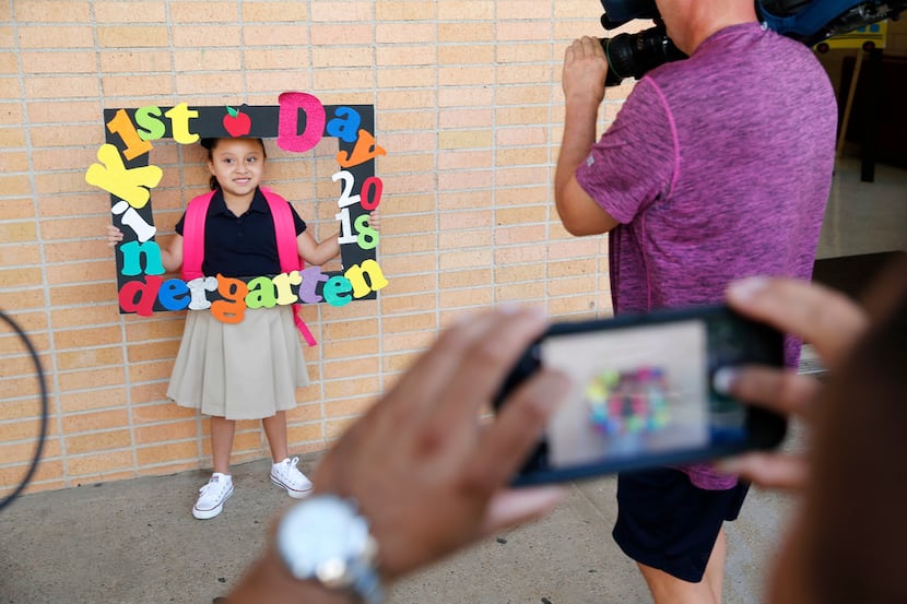 Kindergartner Roseann Arellano, 5, poses with her sign for her father, Juan Arellano on the...