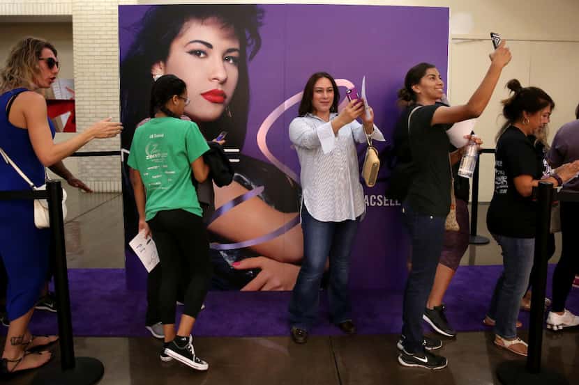 Fans take selfies and wait in line for the MAC Selena collection outside the MAC Cosmetics...