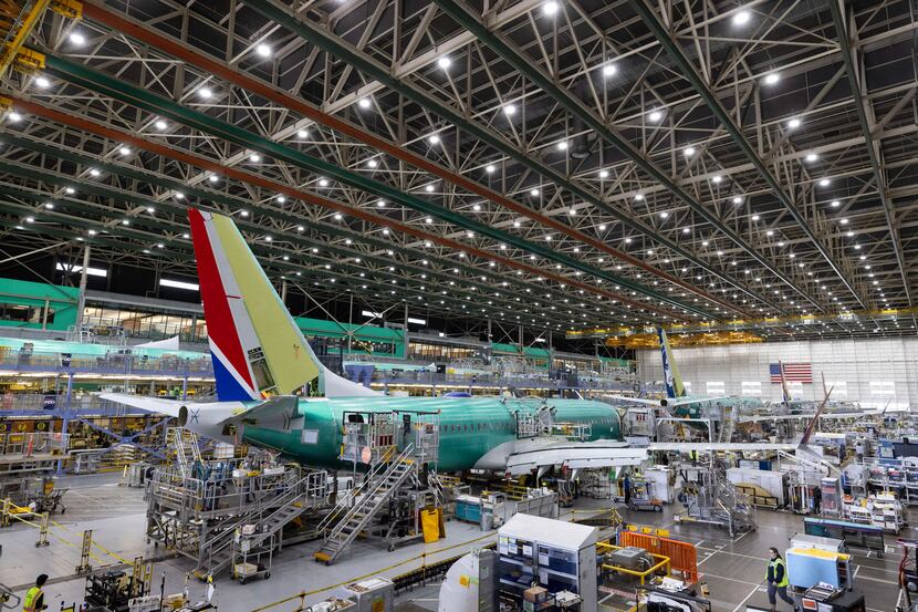Boeing employees work on the 737 MAX on the final assembly line at Boeing's Renton, Wash.,...