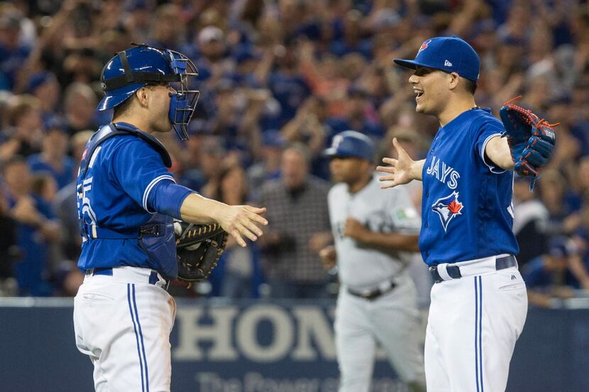 Toronto Blue Jays relief pitcher Roberto Osuna, right, celebrates with catcher Russell...