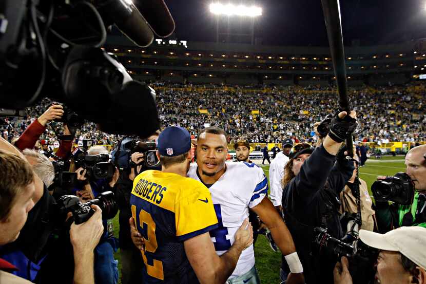 Dallas Cowboys quarterback Dak Prescott (4) hugs Green Bay Packers quarterback Aaron Rodgers...