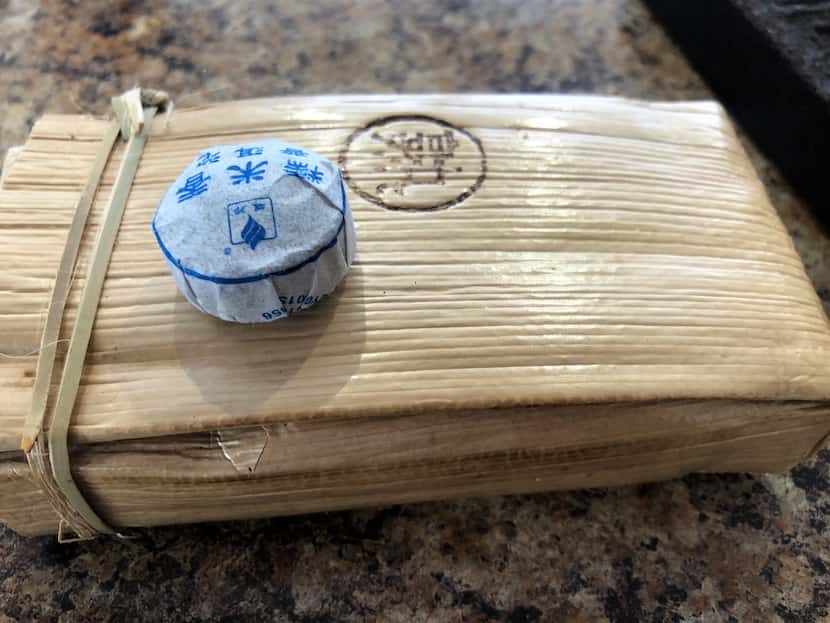 A small coin of Sticky Rice pu'er and a brick of rapidly ripened pu'er at The Cultured Cup.