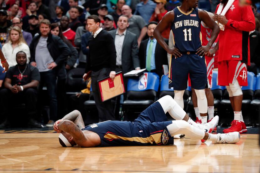 New Orleans Pelicans center DeMarcus Cousins lies on the court after injuring his left...