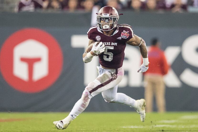 Texas A&M running back Trayveon Williams rushes downfield against North Carolina State...