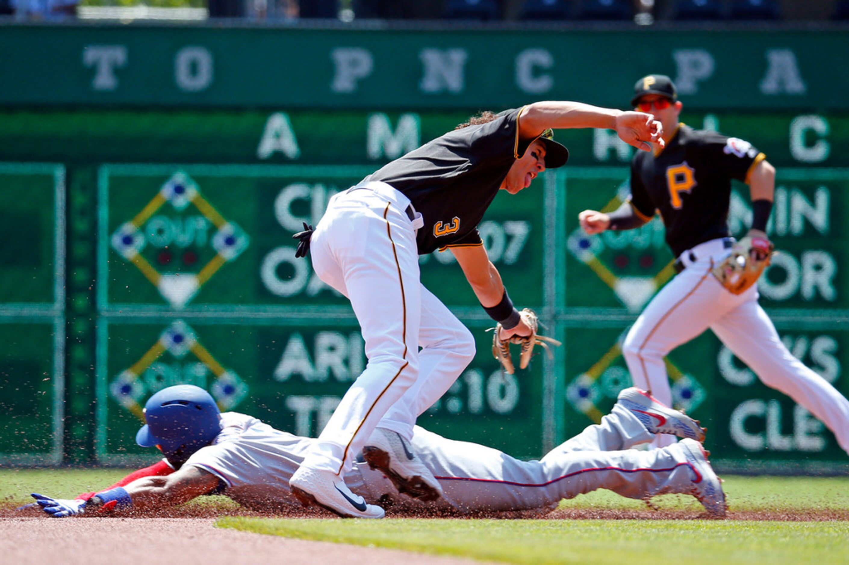 Cole Tucker (3) of the Pittsburgh Pirates attempts to tag out Elvis Andrus (1) of the Texas...