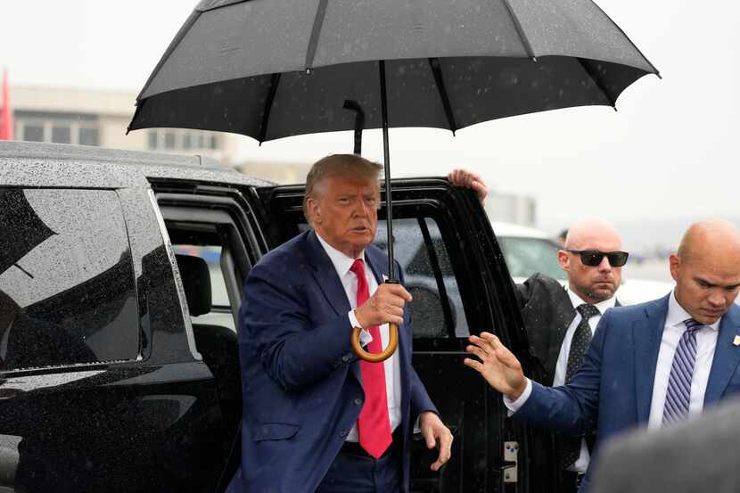 Former President Donald Trump arrives to speak with reporters before he boards his plane at...
