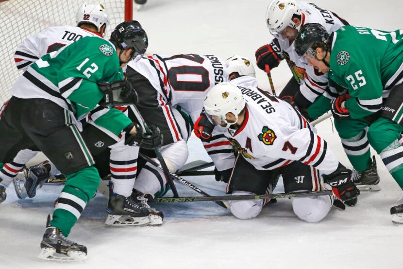 The Stars and Blackhawks tussle for the puck in front of Chicago goalie Corey Crawford (50)...