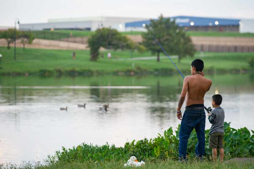 Terrance Hunt shows son Milton Smith Ceren Mejía how to fish as they stand on the northern...