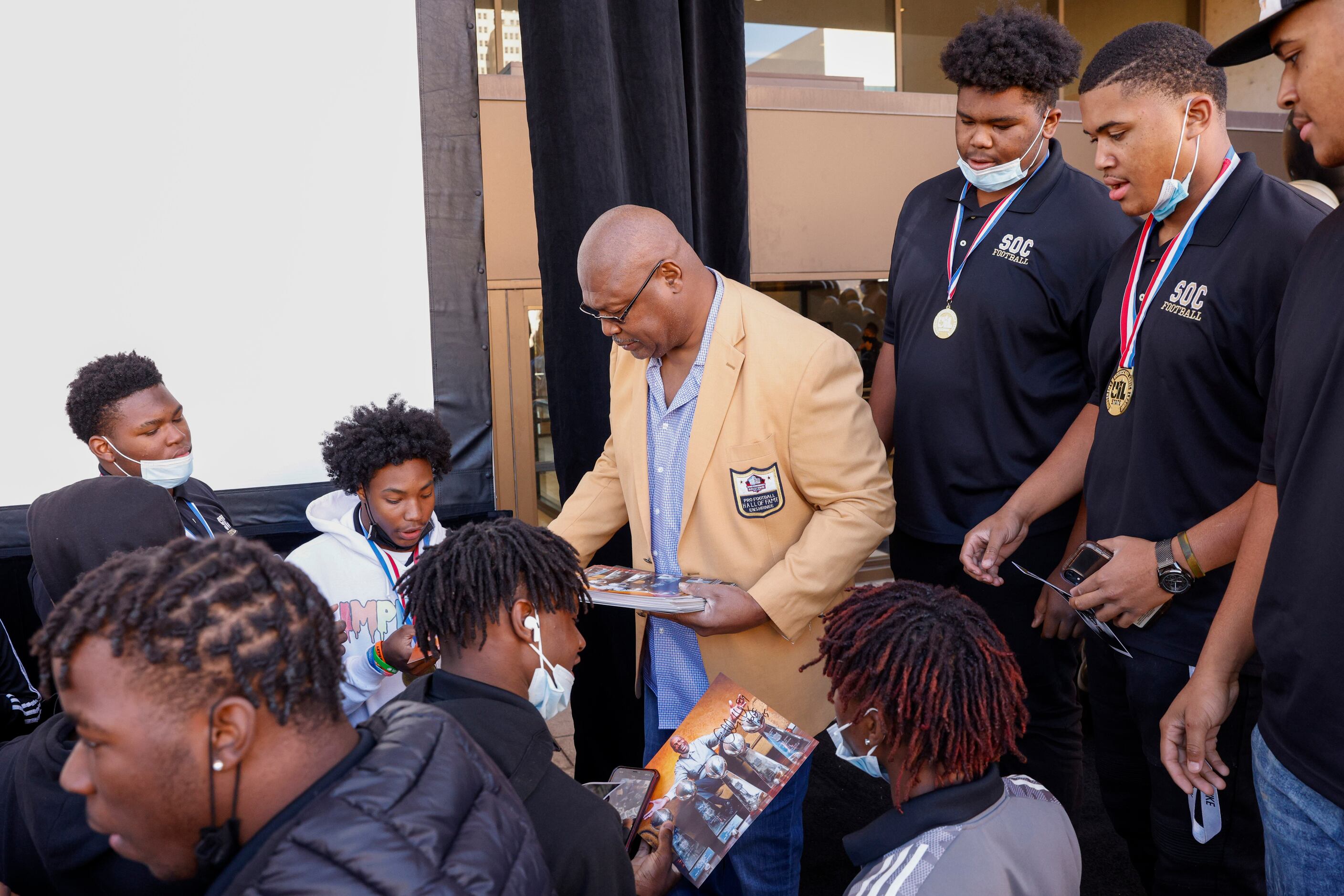 Former Dallas Cowboy Charles Haley hands out autographed photos of himself to South Oak...