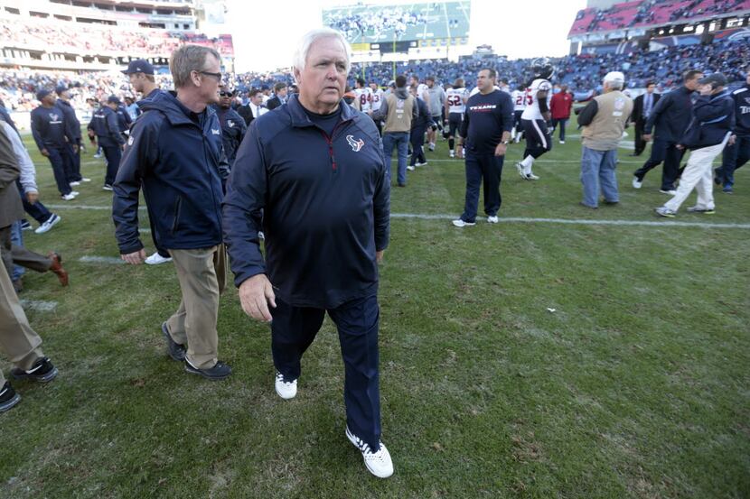Houston Texans interim head coach Wade Phillips, center, leaves the field after losing to...