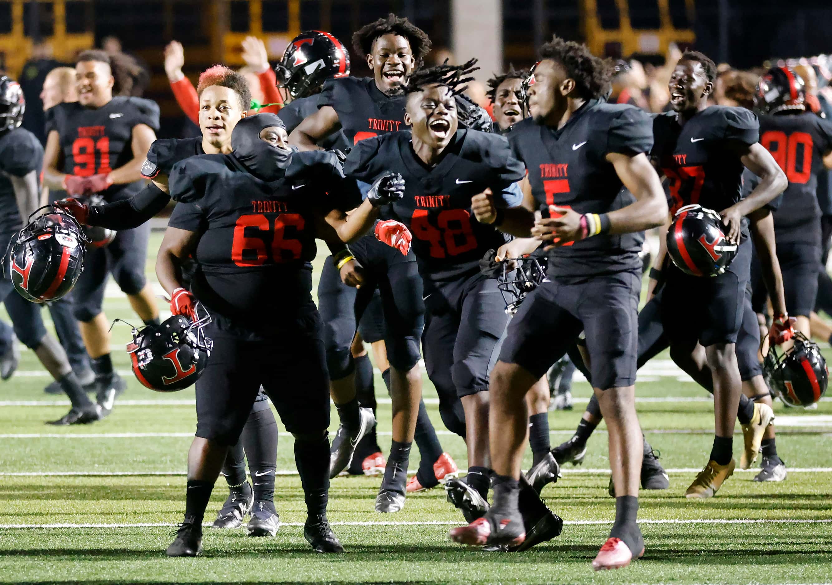 Euless Trinity football players celebrate their overtime win against Hurst L.D. Bell at...