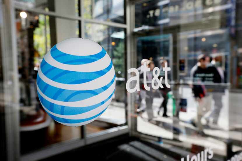 FILE - In this Oct. 17, 2012, photo, an AT&T logo is displayed on an AT&T Wireless retail...