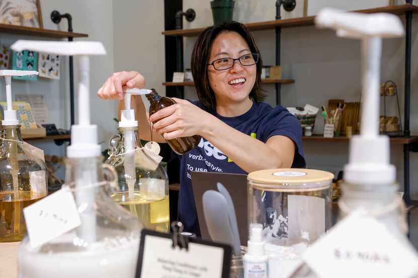 Usefull founder Adriana Kao fills up a customer's bottle with product at her product refill...