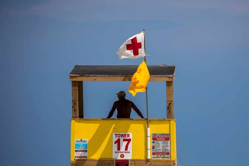 A beach guard looks out from a tower along Port Aransas Beach. Officials say day-trippers...
