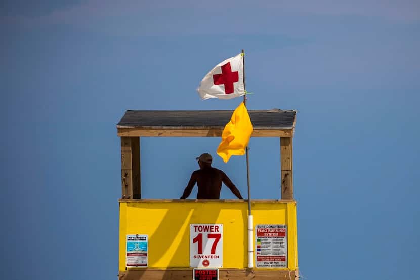 A beach guard looks out from a tower along Port Aransas Beach. Officials say day-trippers...