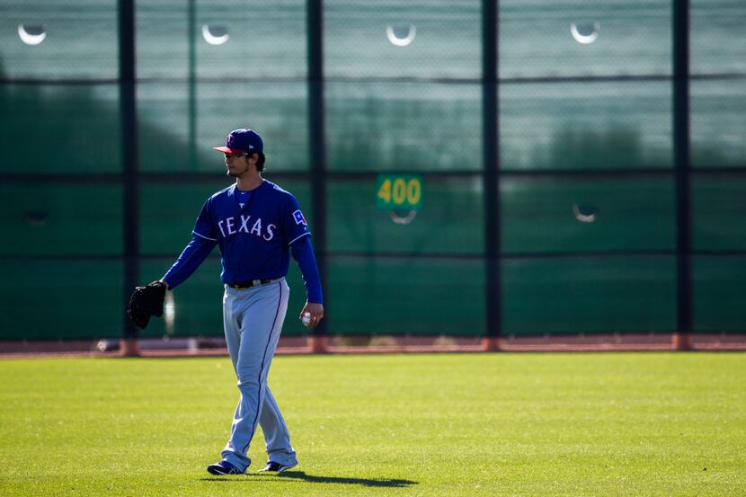 Texas Rangers starting pitcher Yu Darvish (11) walks in the outfield during a spring...
