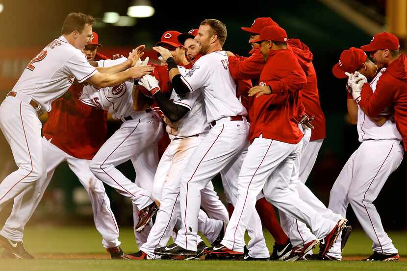 Shin-Soo Choo #17 of the Cincinnati Reds is congratulated by his teammates after hitting a...