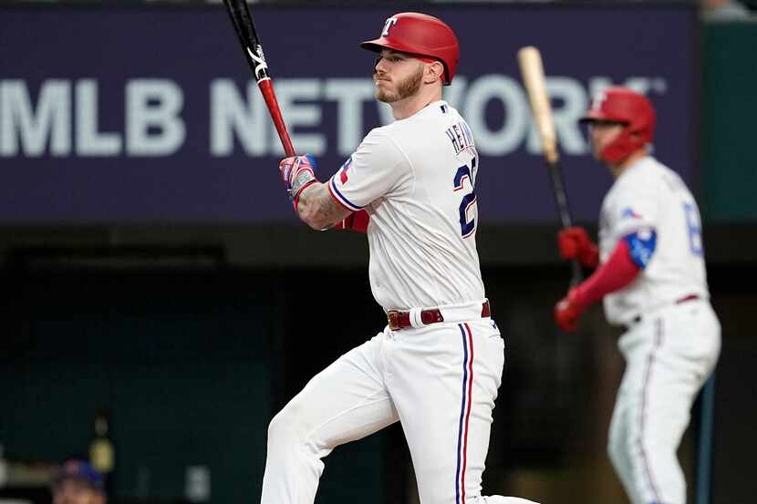 Texas Rangers' Jonah Heim follows through on a two-run double in the first inning of a...