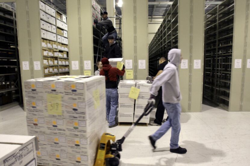 Workers hauled document boxes from George W. Bush’s presidency into storage at a Lewisville...