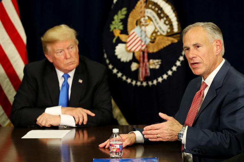 In this file photo, Texas Gov. Greg Abbott speaks while President Donald Trump watches on as...