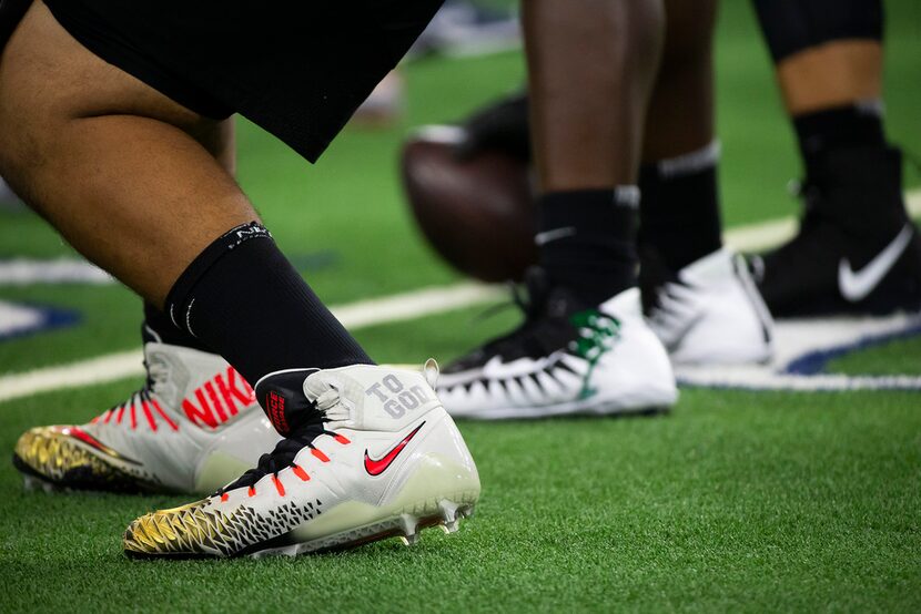 Rows of new Nike cleats are seen as lineman face off during the third day of The Opening at...